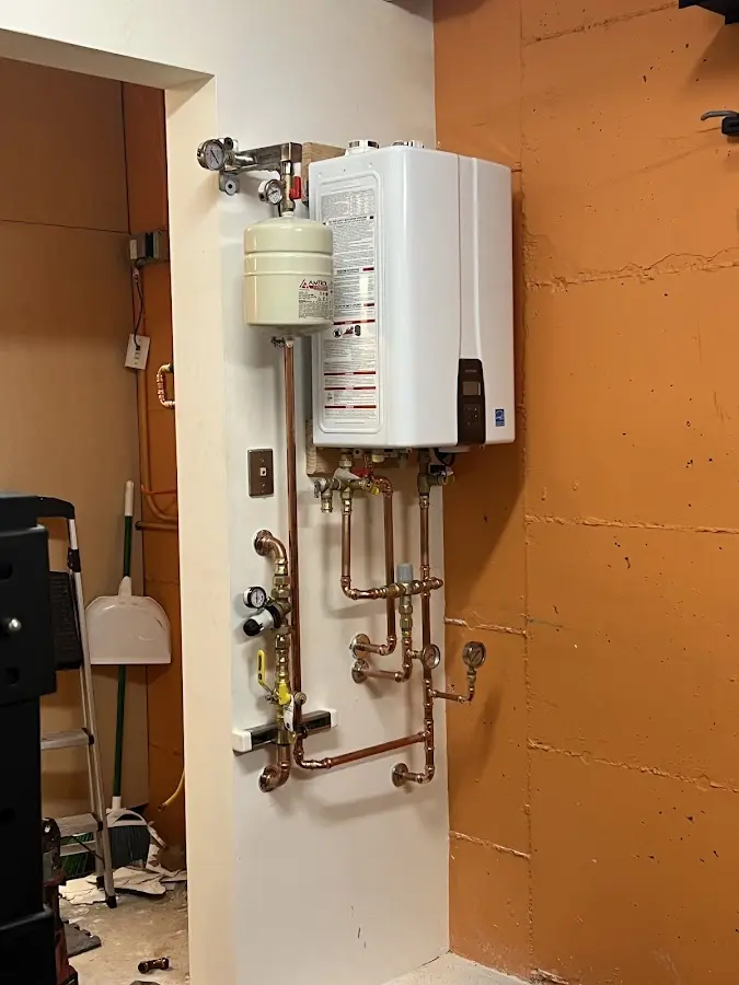 Plumbing technician inspecting water heater connections in Palisades Park